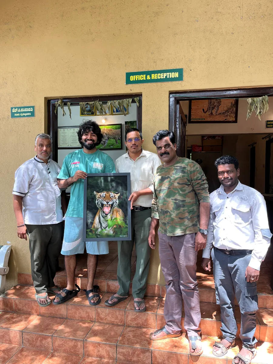 Krishna gifting a framed print of The Warning to the Jungle Lodges team, Bandipur